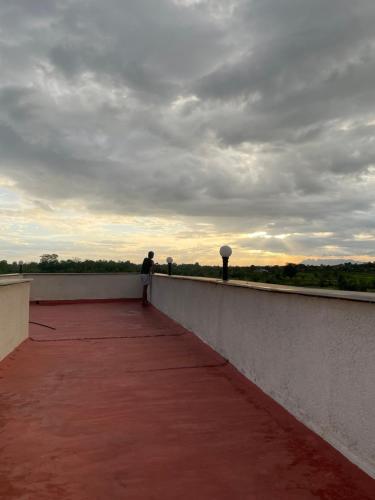 a man is standing on a wall on a roof at Vana The Forest Farm in Saralgaon