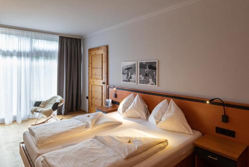 a hotel room with a bed and a chair at Alpenland St Johann in Sankt Johann im Pongau