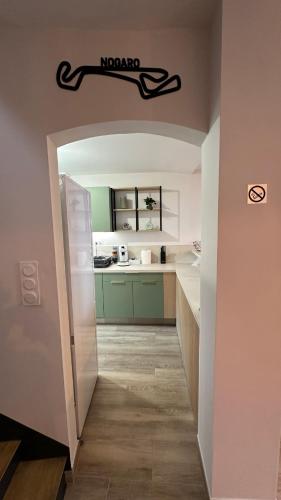 a hallway leading to a kitchen with a refrigerator at Maison centre Nogaro circuit et arènes in Nogaro