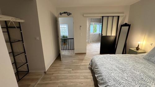 a bedroom with a bed and a hallway with a mirror at Maison centre Nogaro circuit et arènes in Nogaro