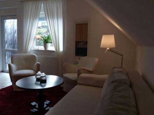 a living room with a couch and chairs and a table at Charmantes Ferienhaus für 4 Personen Nähe Winterberg in Bromskirchen