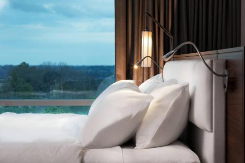 a bed with white pillows in a room with a window at Le Meridien Atlanta Perimeter in Atlanta