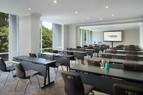 a conference room with tables and chairs and a screen at Le Meridien Atlanta Perimeter in Atlanta