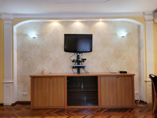 a flat screen tv on top of a entertainment center at Home Hotel Apartments on Kontraktova Ploshcha in Kyiv