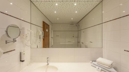 a bathroom with a tub and a sink and a mirror at Alpenland St Johann in Sankt Johann im Pongau