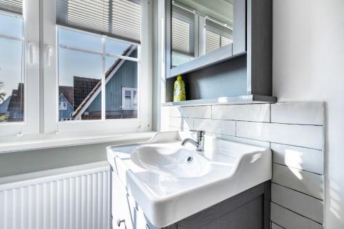 a white bathroom with a sink and a window at Atlanta Pur in Pellworm