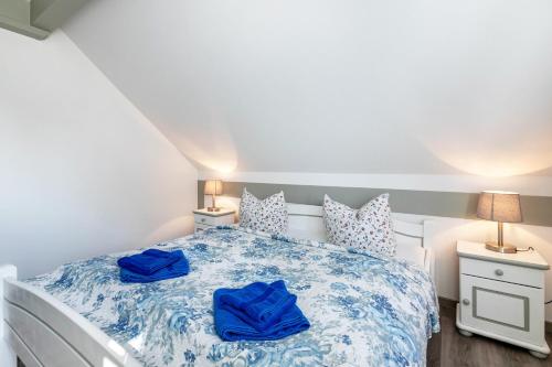 a bedroom with a bed with blue sheets and two lamps at Atlanta Pur in Pellworm