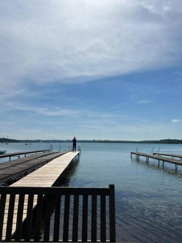a person standing on a dock in the water at bloom - klein und fein mit Seezugang u WLAN in Wörthsee