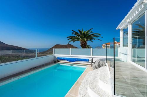 a swimming pool with a view of the ocean from a house at Villa Panorama Chayofa in Chayofa