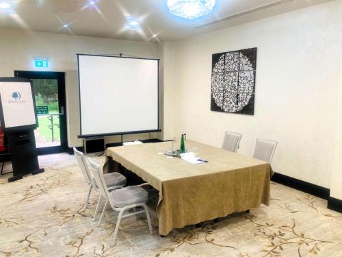 a conference room with a table with chairs and a screen at DoubleTree by Hilton Hotel Nottingham - Gateway in Nottingham