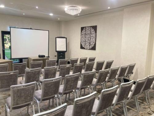 a conference room with chairs and a white screen at DoubleTree by Hilton Hotel Nottingham - Gateway in Nottingham