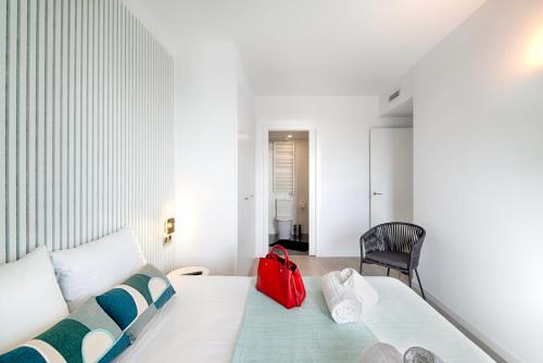 una bolsa roja sentada en una cama en una habitación en Seaside Badalona Apartment, en Badalona