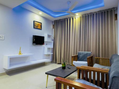 a living room with a blue ceiling at Veu Ragamalika Apartment with Fully Equipped Kitchen, Balcony & Caretaker in Cochin