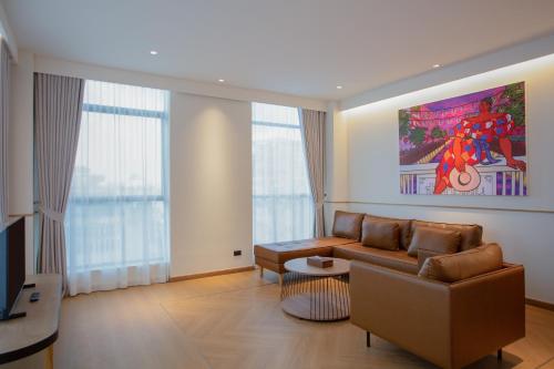 a living room with a couch and a painting on the wall at Lub d Bangkok Chinatown - Steps from Sam Yod MRT Station in Bangkok