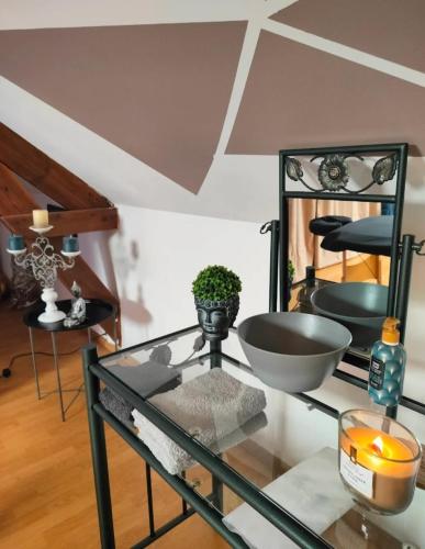 Cette chambre dispose d'une table en verre avec un bol. dans l'établissement Fleurs de Lys, à Friville-Escarbotin