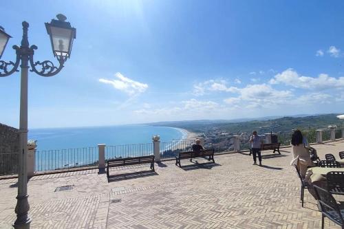 a group of people sitting on benches overlooking the ocean at Vasto House in Vasto
