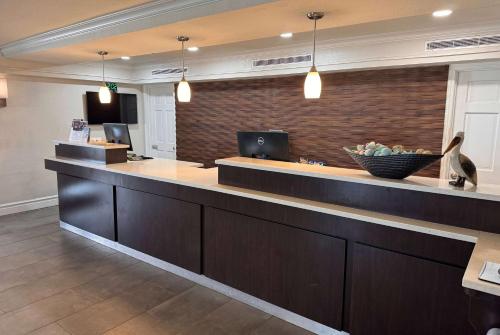 a lobby with a counter with a bowl of fruit at Wingate by Wyndham Galveston Beachfront at the Seawall in Galveston