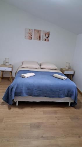 une chambre avec un lit avec une couverture bleue dans l'établissement Maison de ville - La Sauvetat, à La Sauvetat