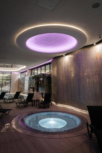 a hot tub in a lobby with a purple ceiling at Hotel Ivascu in Moisei