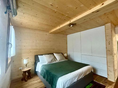 a bedroom with a bed in a wooden room at Nido Ampezzano in Borca di Cadore