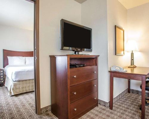 a hotel room with a television on top of a dresser at MainStay Suites St Robert - Fort Leonard Wood in Saint Robert