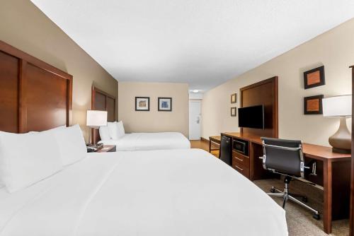 a hotel room with two beds and a desk at Comfort Inn & Suites Durham near Duke University in Durham