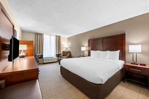 a hotel room with a large bed and a television at Comfort Inn & Suites Durham near Duke University in Durham