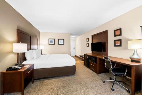 a hotel room with a bed and a desk and a computer at Comfort Inn & Suites Durham near Duke University in Durham