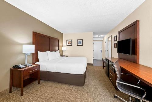 a hotel room with a bed and a flat screen tv at Comfort Inn & Suites Durham near Duke University in Durham