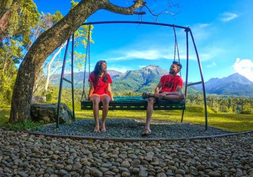 a man and a woman sitting on a swing at Belihuloya Hideout Villa in Belihul Oya