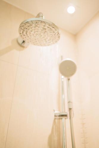 a shower in a bathroom with a shower curtain at Klostermaier Hotel & Restaurant in Icking