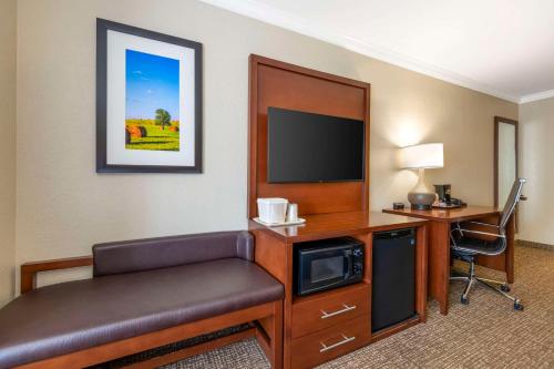 a hotel room with a desk and a tv at Comfort Suites in Elizabethtown