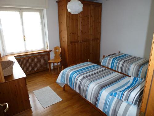 - une chambre avec deux lits, une fenêtre et une chaise dans l'établissement Appartamento Sole, à Borca di Cadore
