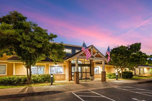 a building with american flags in a parking lot at AmericInn by Wyndham North Branch in North Branch