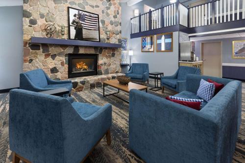 a living room with blue chairs and a fireplace at AmericInn by Wyndham North Branch in North Branch