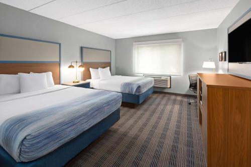 a hotel room with two beds and a television at AmericInn by Wyndham North Branch in North Branch