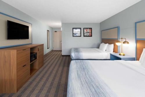 a hotel room with two beds and a flat screen tv at AmericInn by Wyndham North Branch in North Branch