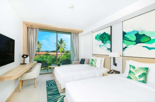 a hotel room with two beds and a window at Hilton Garden Inn Phuket Bang Tao in Bang Tao Beach