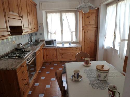 - une cuisine avec des placards en bois et une table avec des tasses dans l'établissement Appartamento Sole, à Borca di Cadore