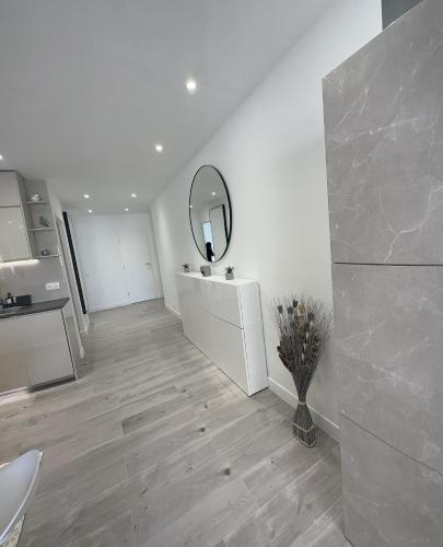 Cette chambre blanche dispose d'une coiffeuse et d'un miroir. dans l'établissement Appartement luxueux 110m collé au prestigieux hôtel le MARTINEZ, à Cannes