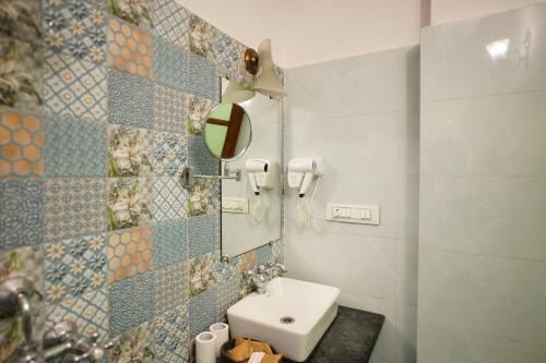 a bathroom with a sink and a mirror at Haveli Kalwara - A Heritage Hotel in Jaipur