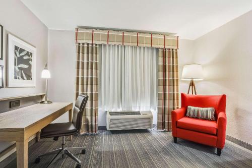 a hotel room with a desk and a red chair at Country Inn & Suites by Radisson, Green Bay, WI in Ashwaubenon