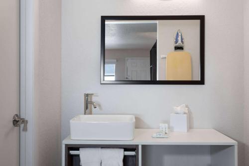 a bathroom with a sink and a mirror at Howard Johnson by Wyndham Orlando Lake Buena Vista South in Kissimmee
