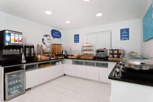 a kitchen with a counter in a restaurant at Howard Johnson by Wyndham Orlando Lake Buena Vista South in Kissimmee
