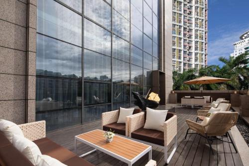 a patio with chairs and tables on a building at Hilton Garden Inn Beihai Jiafu in Beihai