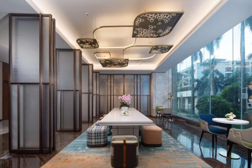 a lobby with a table and chairs and a large window at Hilton Garden Inn Beihai Jiafu in Beihai