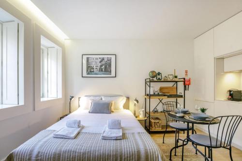 a bedroom with a bed and a table and chairs at Door 65 - Historical Center Apartments in Porto