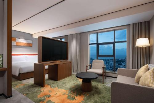 a hotel room with a bed and a flat screen tv at Hilton Garden Inn Beihai Jiafu in Beihai