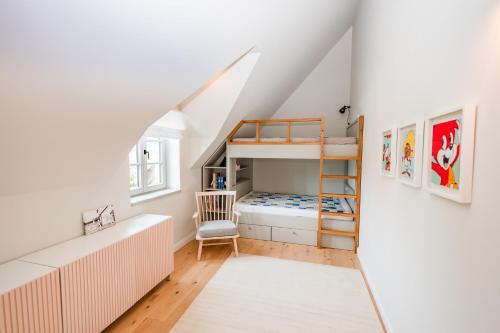 a small attic bedroom with a bunk bed and a ladder at Storchennest in Wyk auf Föhr
