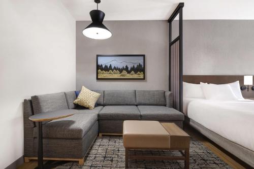a living room with a couch and a bed at Hyatt Place Flagstaff in Flagstaff